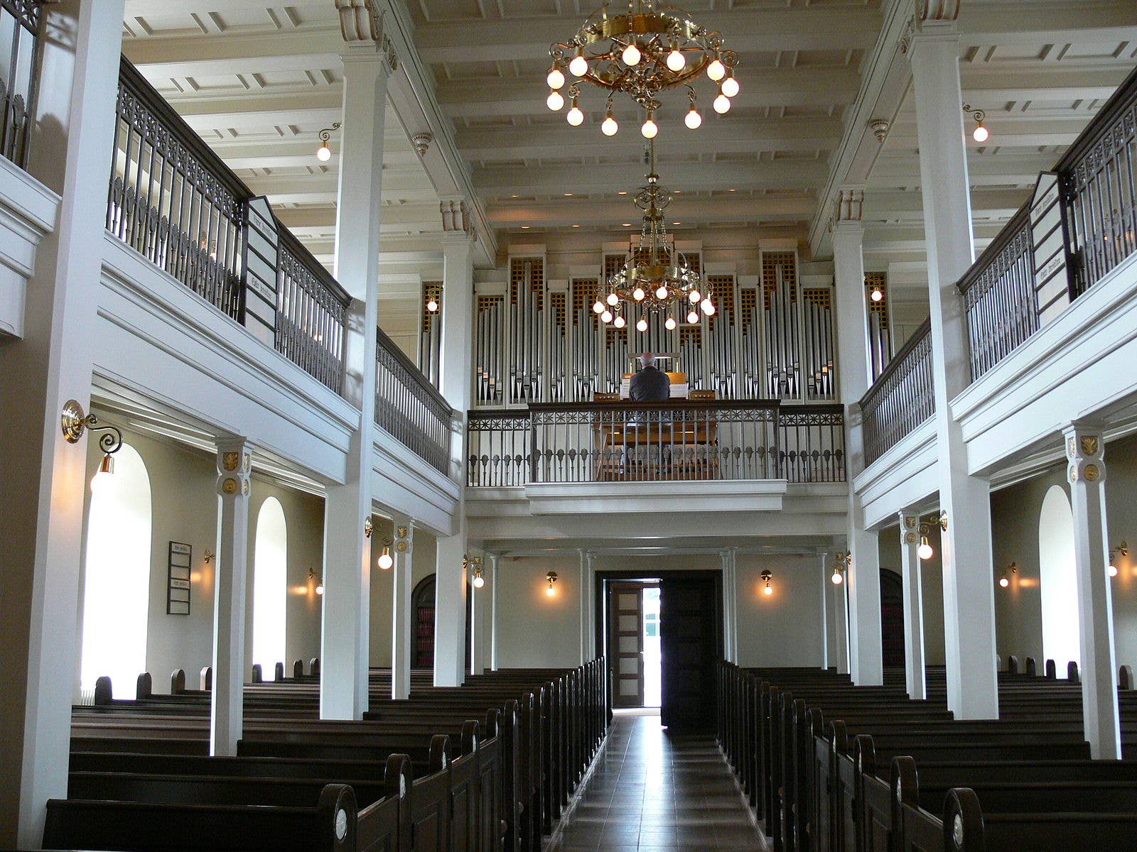 Interior of Dómkirkjan with wooden pews, chandeliers, and the organ gallery