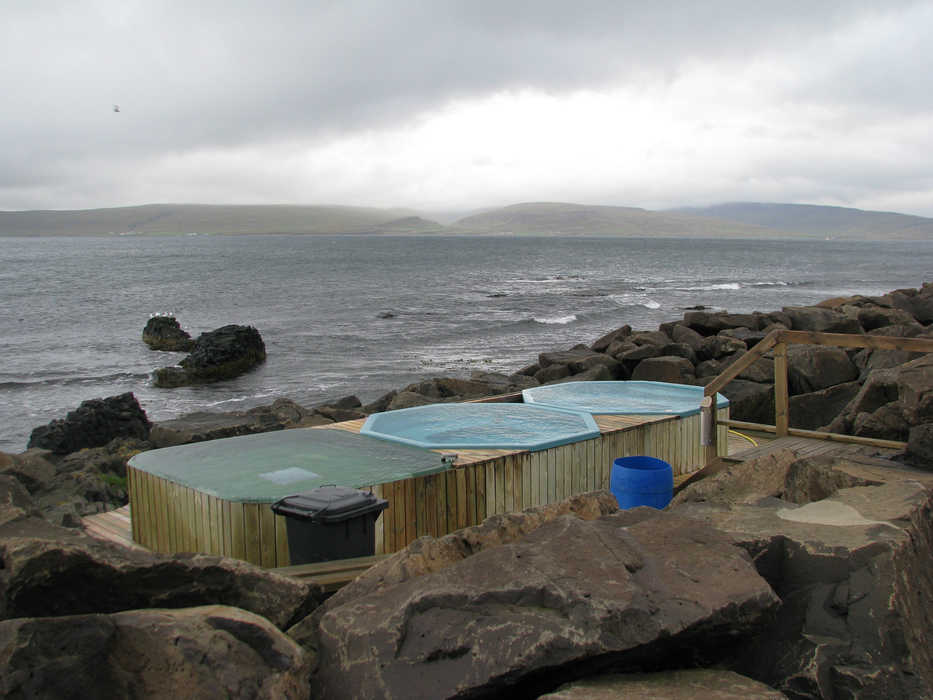 Three Drangsnes Hot Tubs beside Steingrímsfjörður on a cloudy Westfjords day.