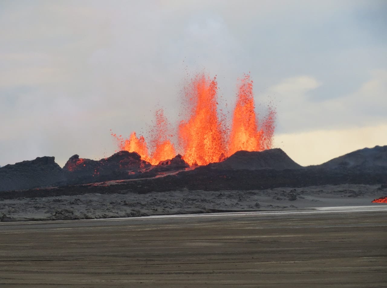 Dark Holuhraun lava and distant highland mountains near the Askja and Dyngjufjoll area.