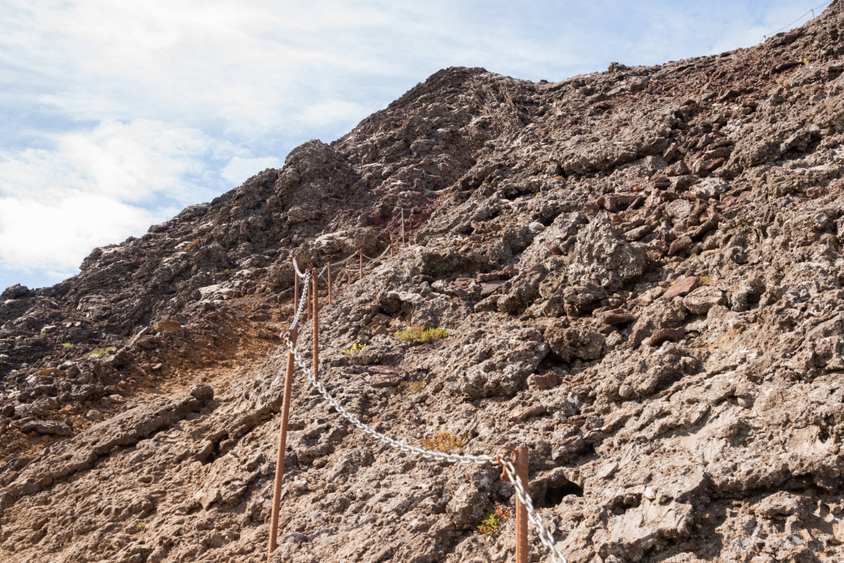 Chain handline and rough lava steps climbing the side of Eldborg crater.