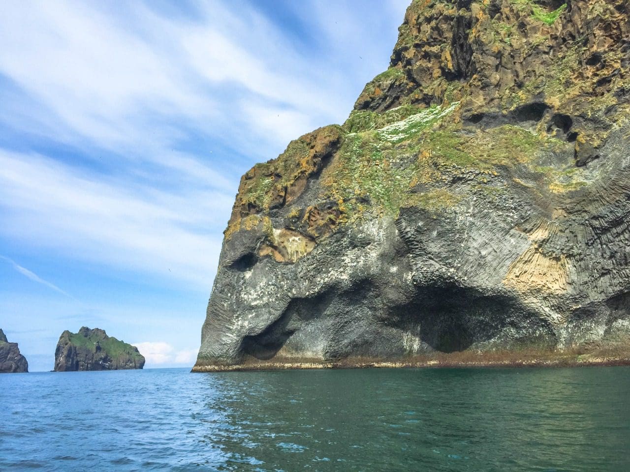 Wider view of Elephant Rock's basalt sea cliff and the surrounding water off Heimaey.