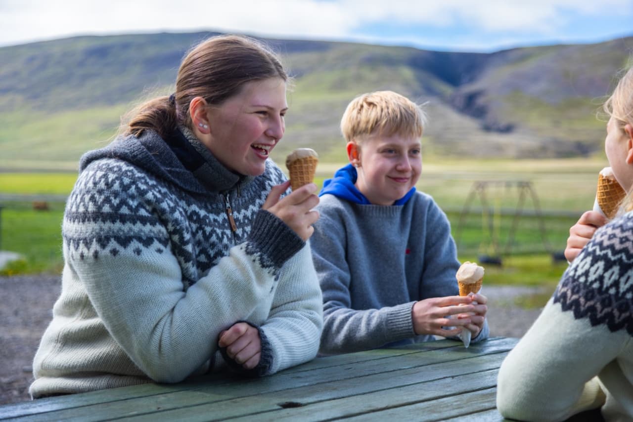 A family eating ice cream at an outdoor table at Erpsstaðir.