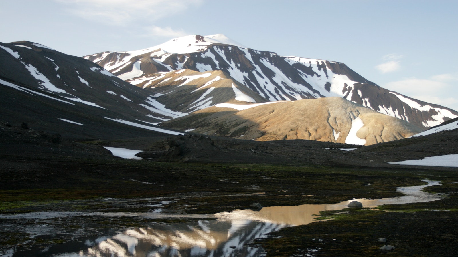 Snow-streaked slopes and wet ground near the Snæfell highland routes above Eyjabakkar.