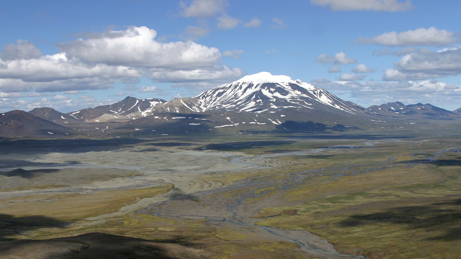 Eyjabakkar wetland and braided glacial channels below snow-streaked Snæfell in East Iceland.