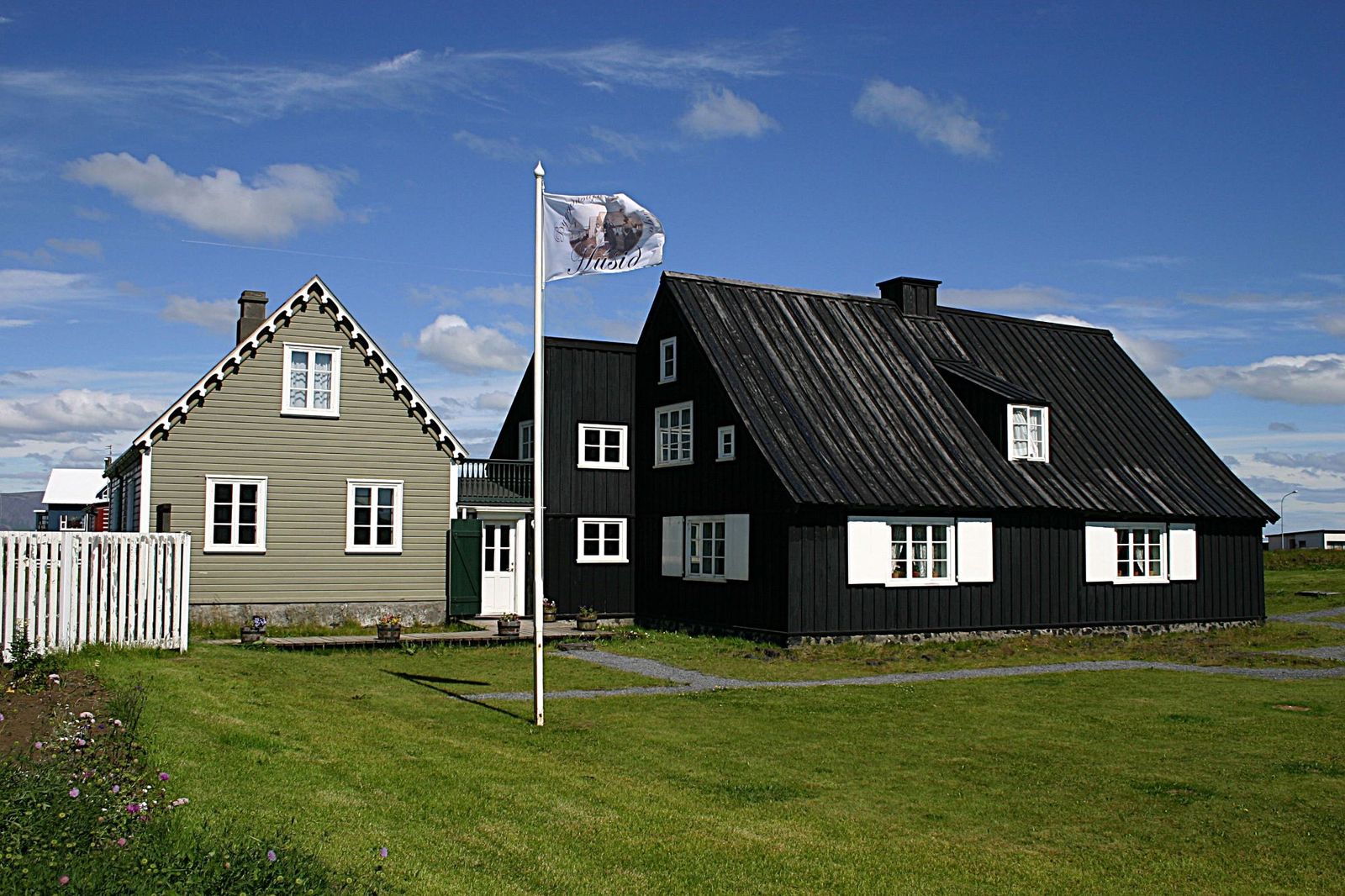 Húsið and Assistentahúsið at Eyrarbakki under a blue sky.