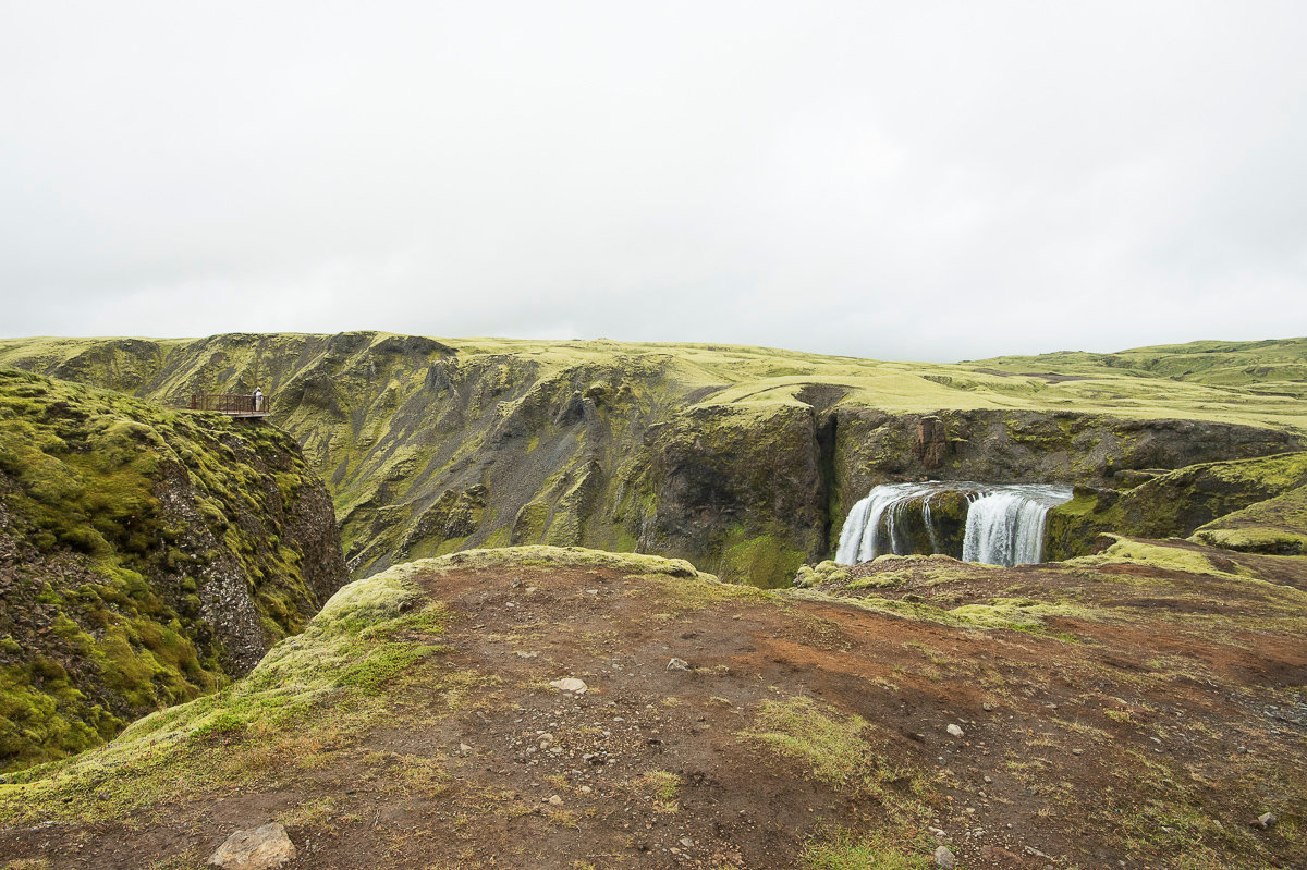Fagrifoss waterfall seen from the canyon rim with a viewing platform on the opposite side.