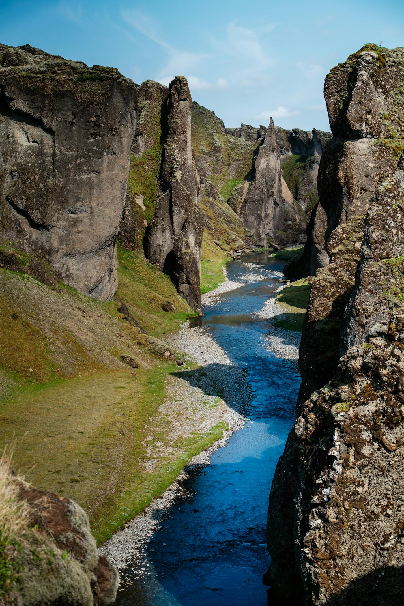 Fjaðrárgljúfur Canyon river channel between steep mossy rock walls.