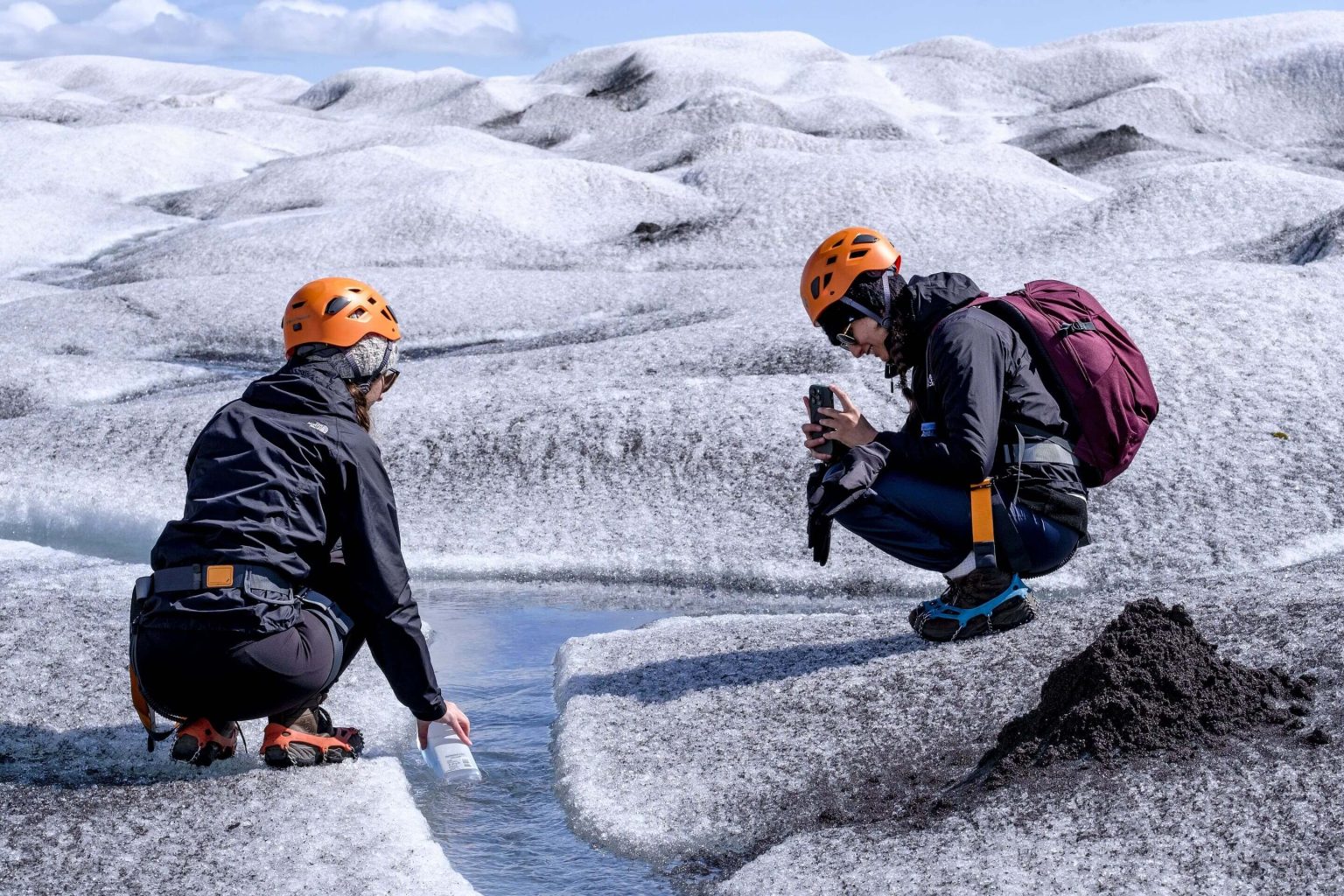 Guided visitors near glacier ice in the Fjallsárlón area.
