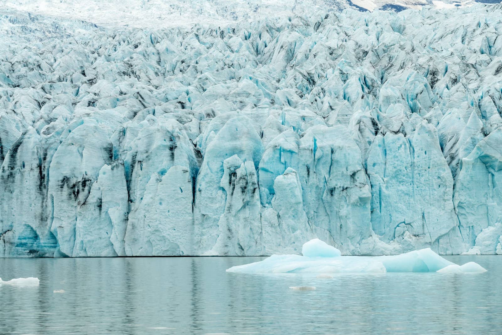 Glacier wall and blue icebergs at Fjallsárlón Glacier Lagoon in southeast Iceland.