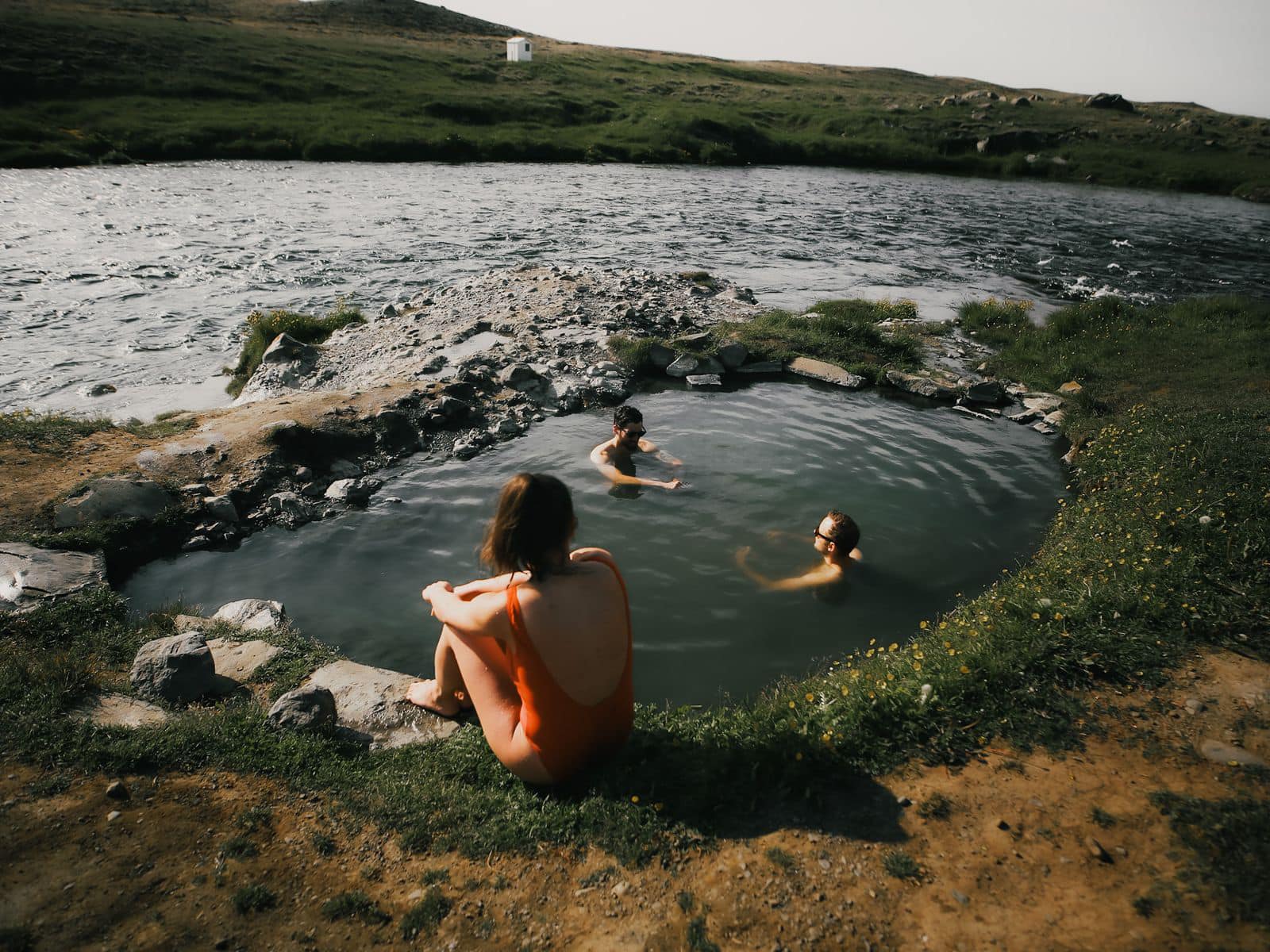 The small stone-lined Fosslaug Hot Spring beside the river near Reykjafoss.