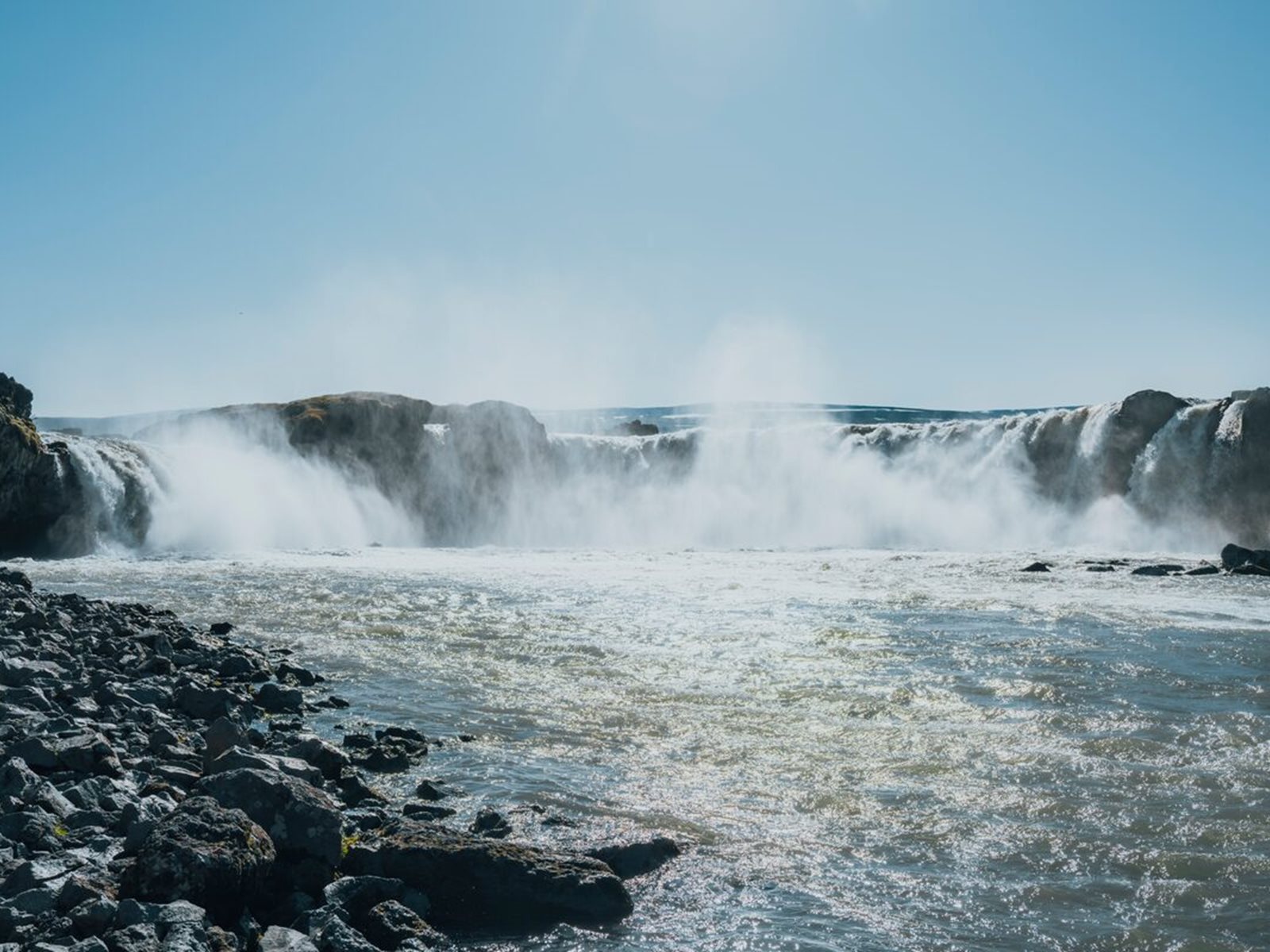 Goðafoss waterfall flowing across a wide rocky ledge in North Iceland