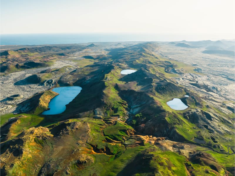 Aerial view of Sveifluháls ridges and crater lakes in the Reykjanes geosite landscape near Grænavatn.