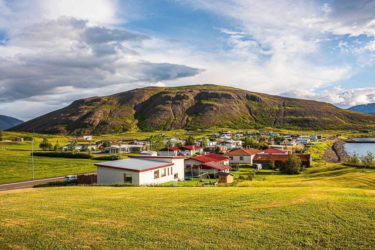 Grenivík harbor and boats with the village and mountain slopes behind.