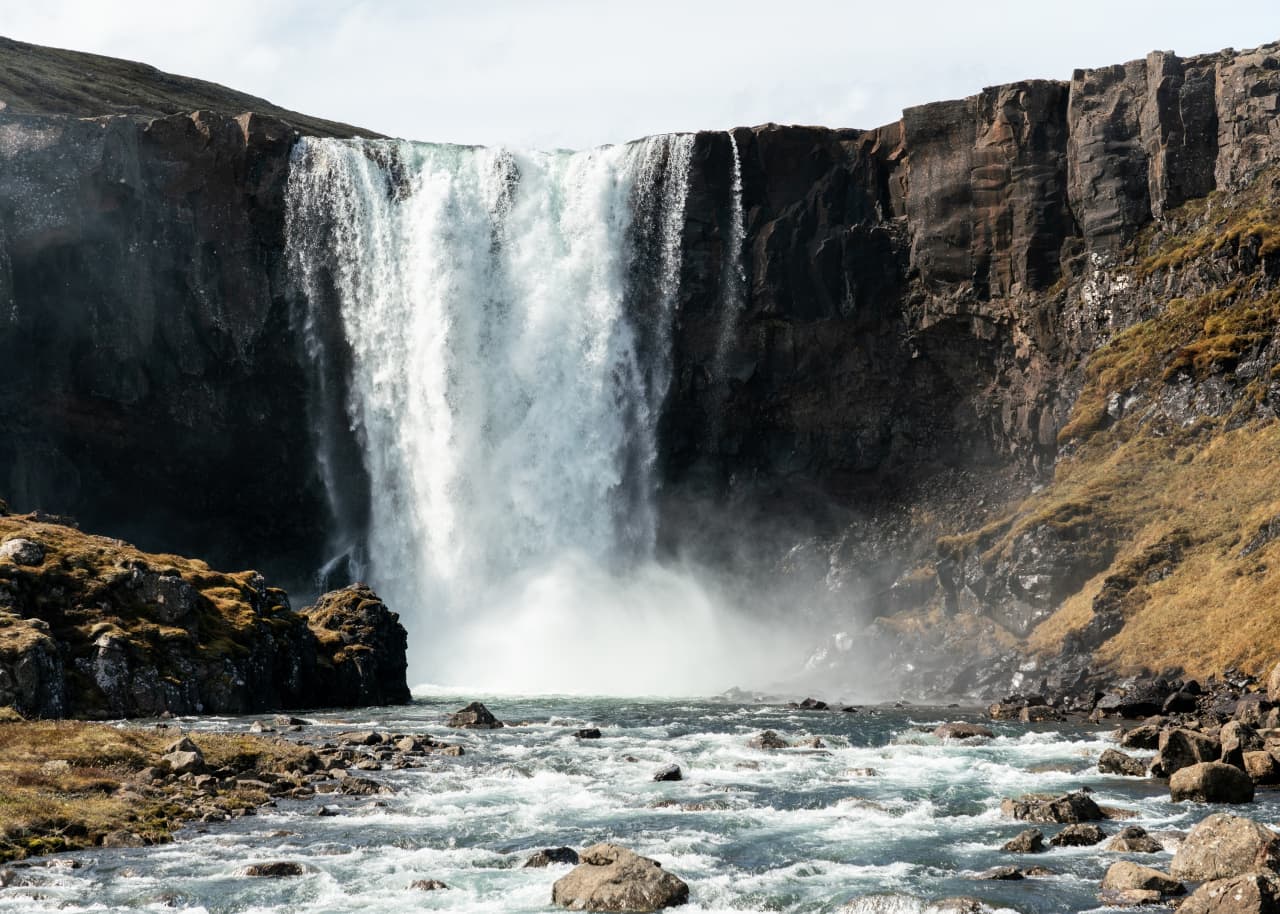 Gufufoss Waterfall dropping into a rocky river below the Road 93 approach near Seyðisfjörður.