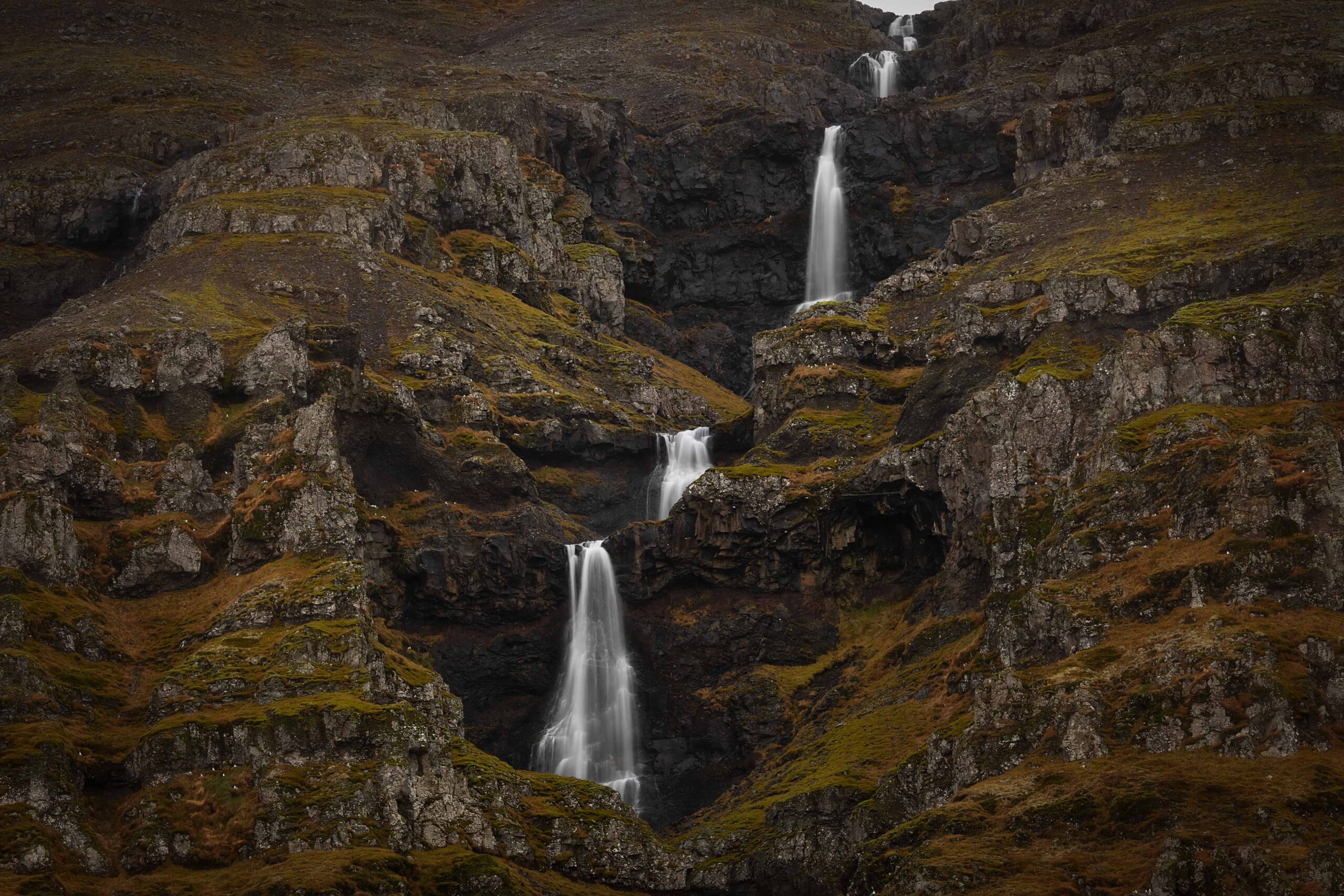 Hænubrekkufoss dropping through a green gorge above Berufjörður in East Iceland.