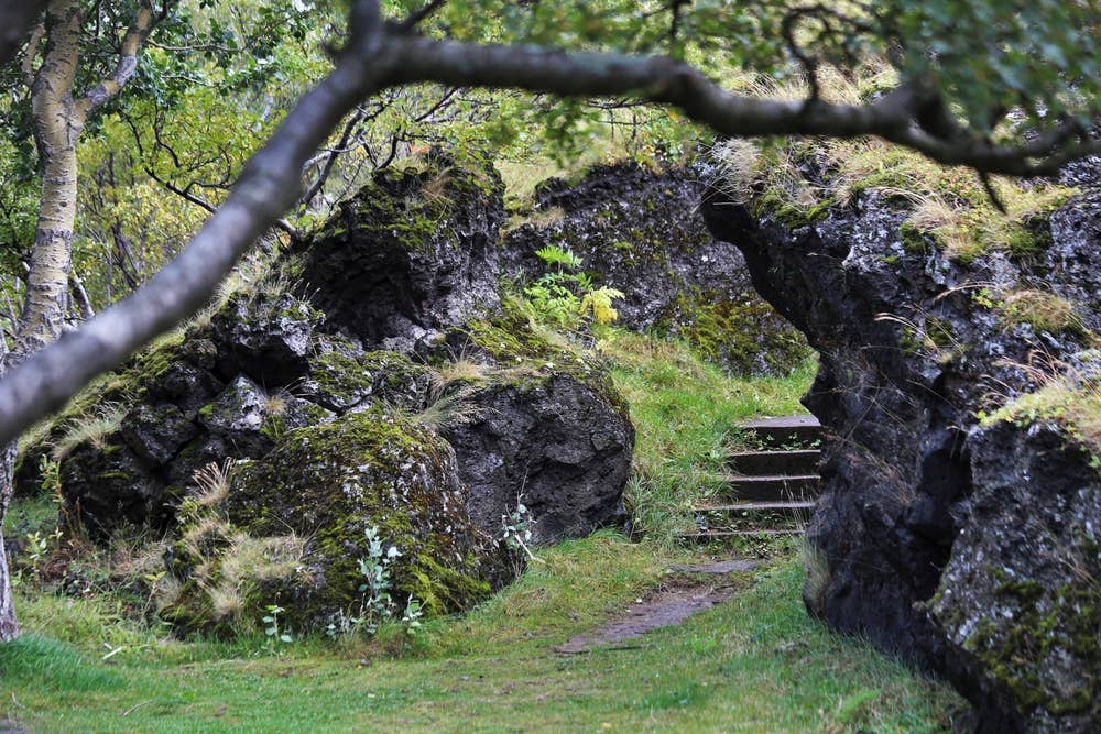 Mossy lava rocks and a narrow path in Hellisgerði Park in Hafnarfjörður.