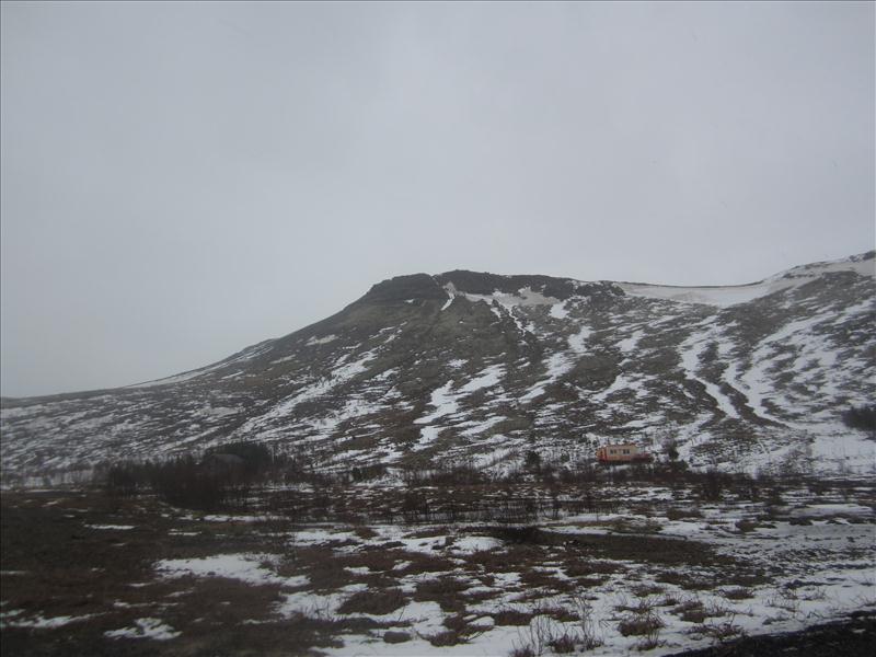Snow patches on the dark lower slopes of Hafrafell above Mosfellsbær.