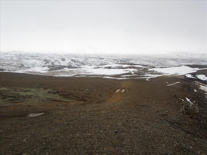 A rough brown Hafrafell ridge with snow-covered hills fading into low cloud.