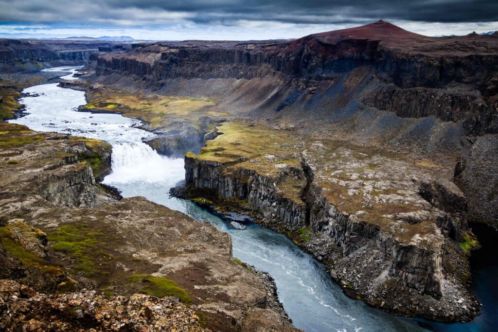 Hafragilsfoss waterfall seen from above with Jökulsárgljúfur cliffs and the glacial river below.