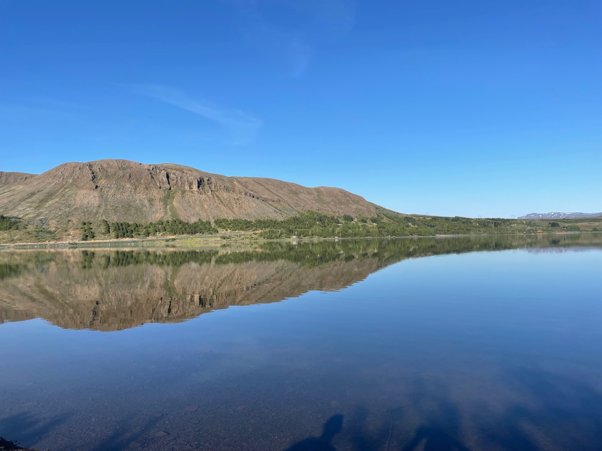 Still water at Hafravatn reflecting the slopes of Hafrafell near Mosfellsbær.