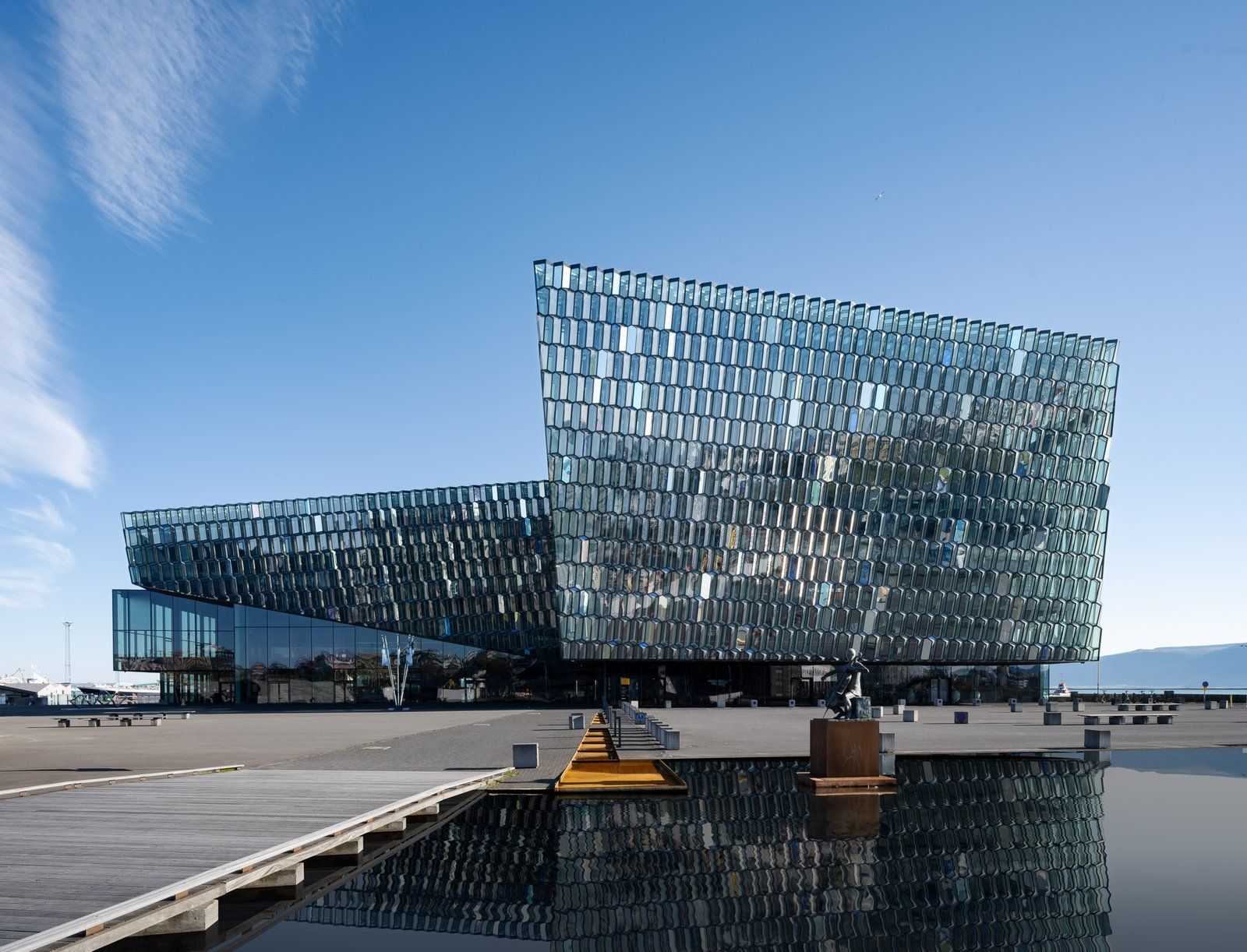Harpa Concert Hall glass facade and plaza reflected in water in Reykjavík