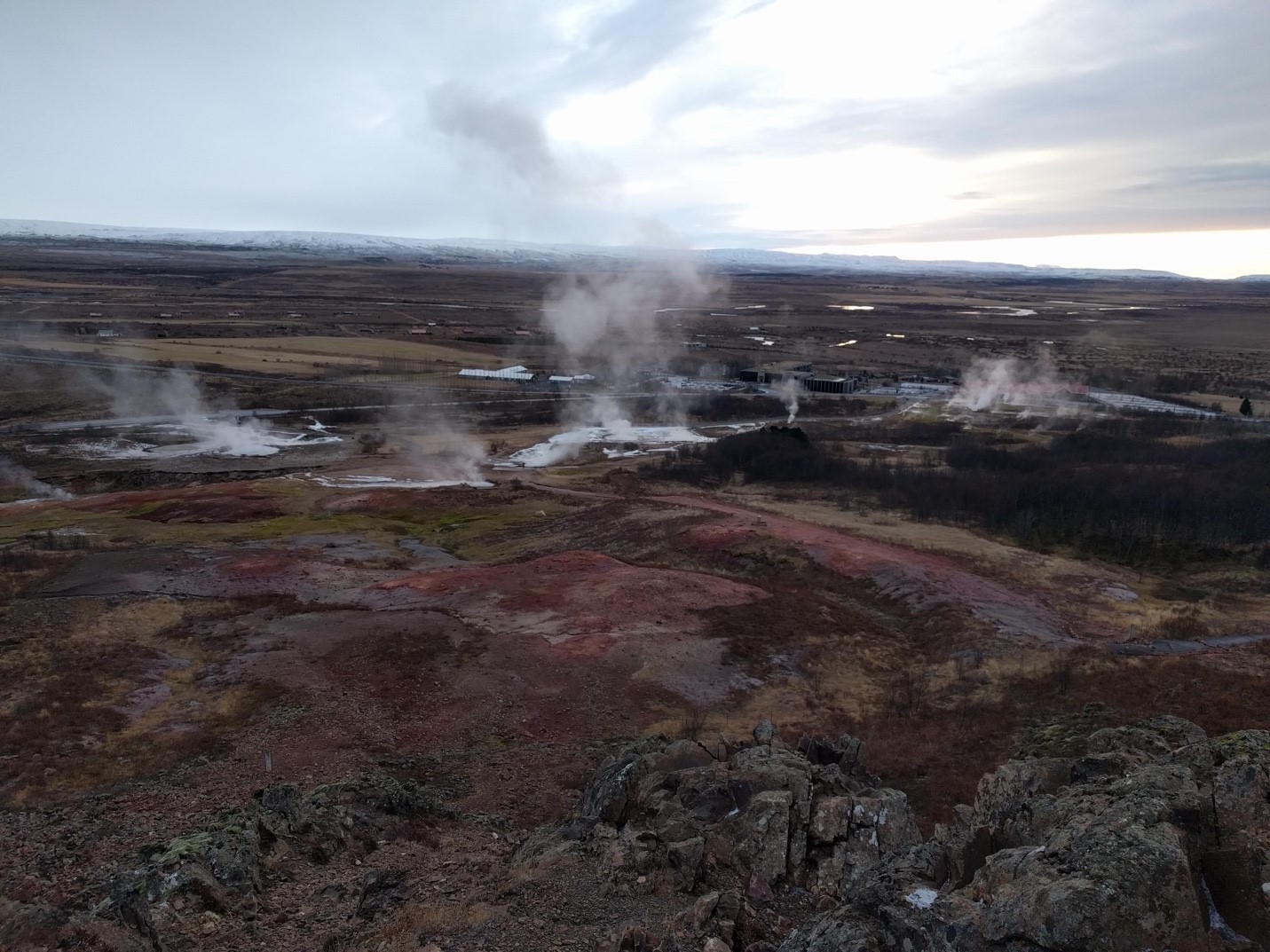 Steam and geothermal ground across Haukadalur viewed from the Laugarfell side of the Geysir area.