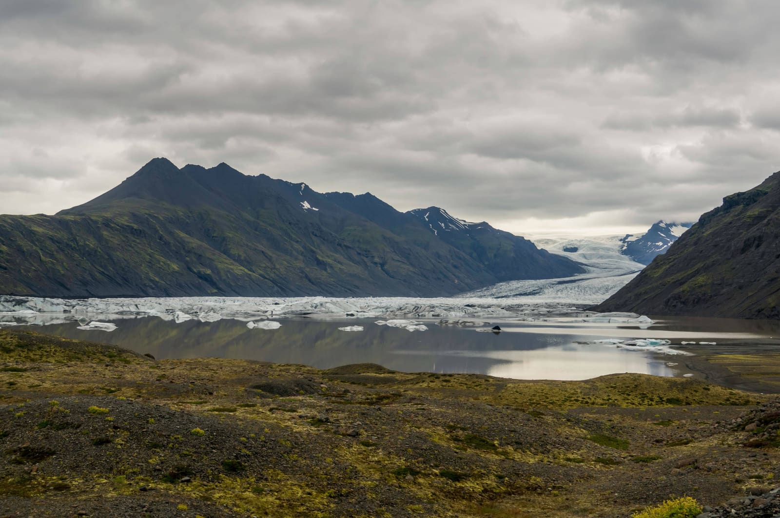 Heinabergslón glacier lagoon below dark mountains and Heinabergsjökull in southeast Iceland.