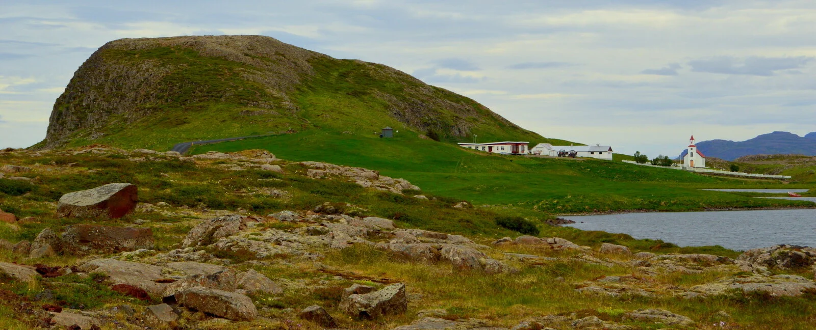 Helgafell rising behind Helgafell church and farm buildings near Stykkishólmur.