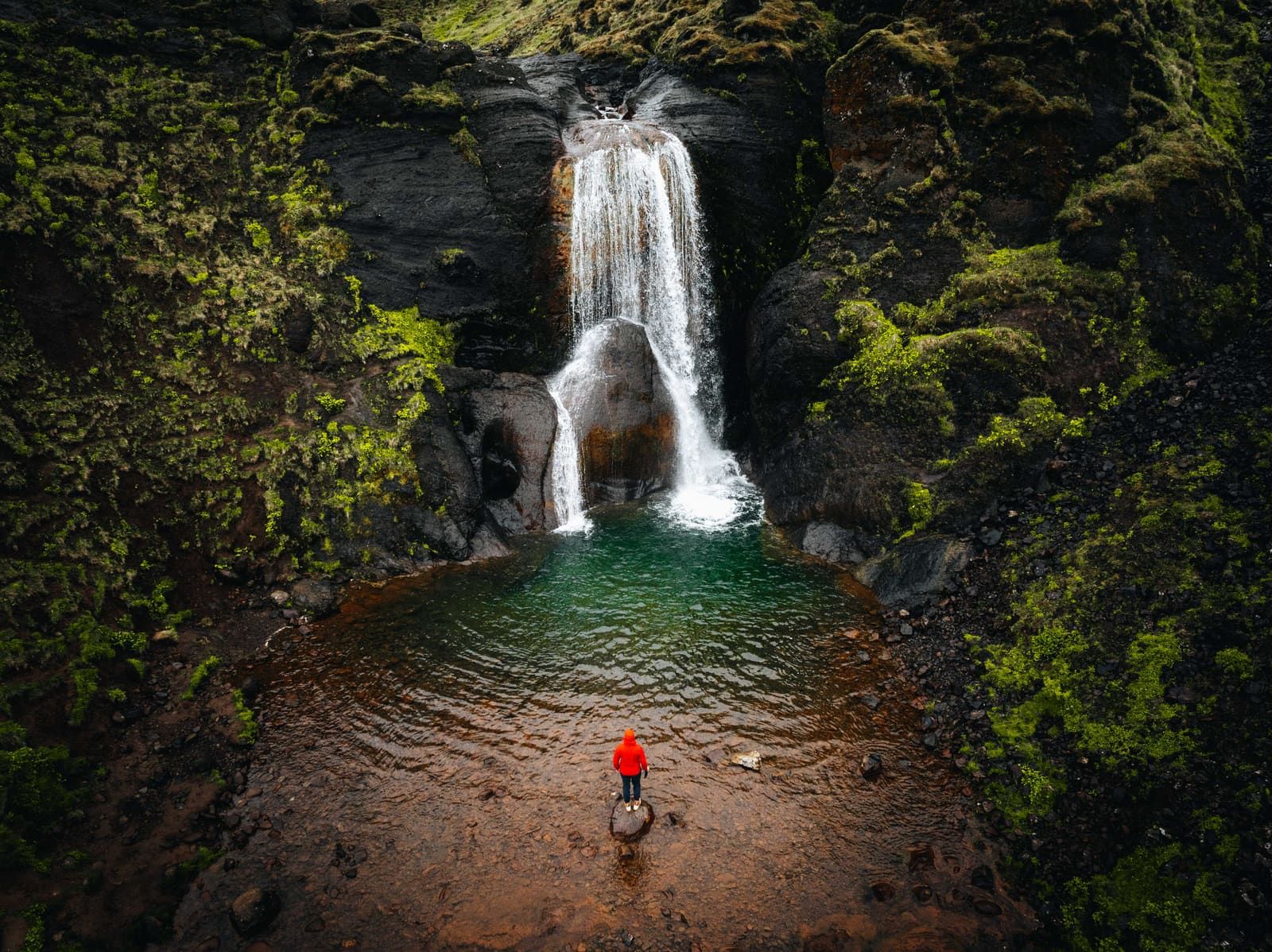 Helgufoss dropping over dark volcanic rock into a pool in Mosfellsdalur.