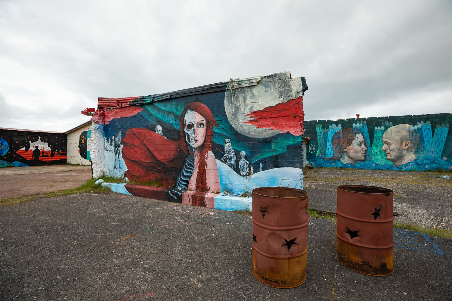 Colorful murals painted across old concrete walls in Hellissandur village.
