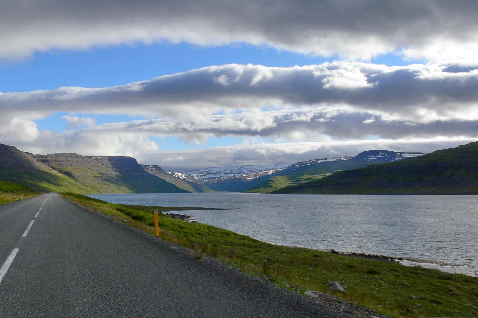 Road 61 beside Hestfjörður with the fjord narrowing between green Westfjords mountains.