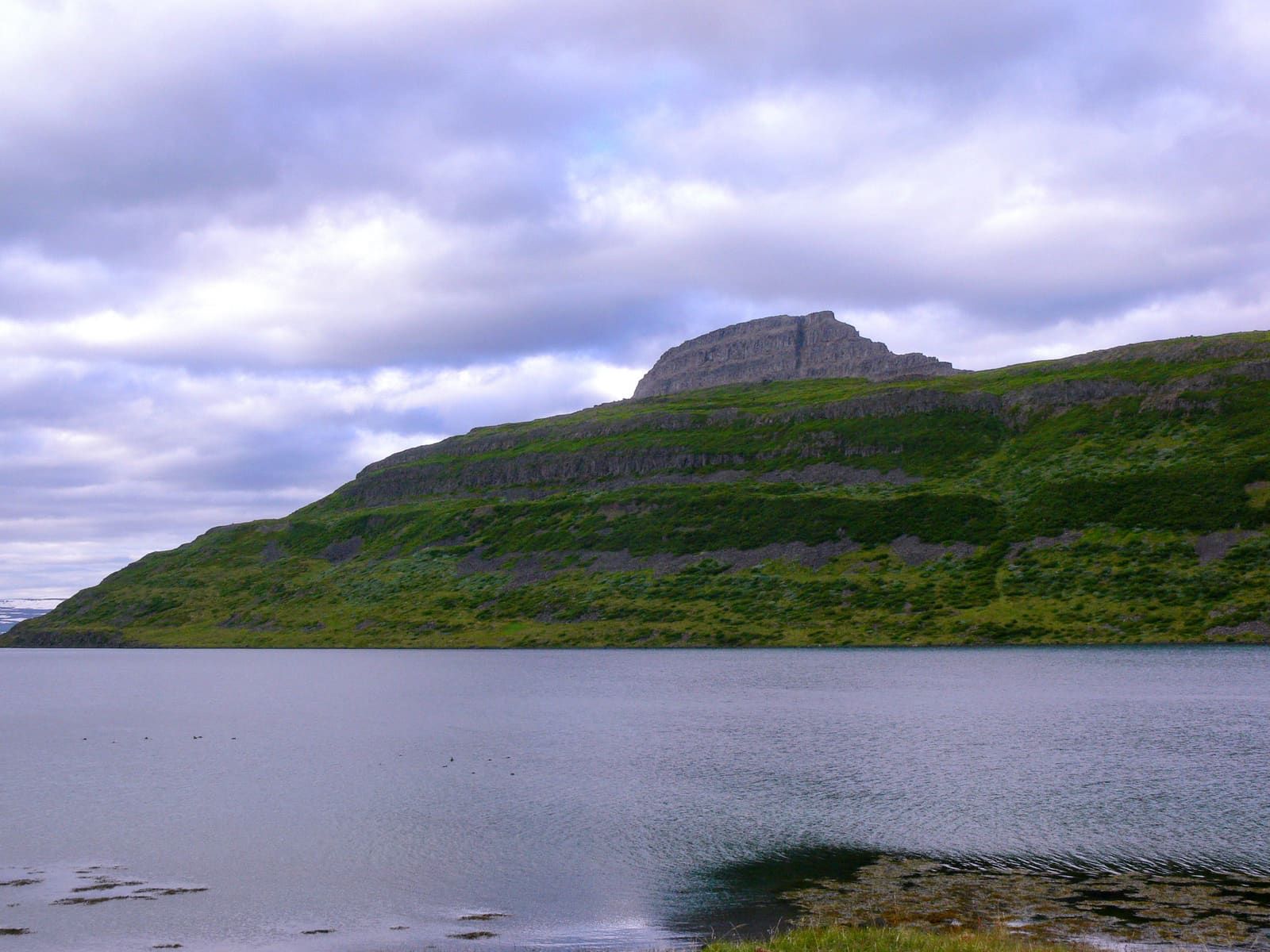 Hestur mountain rising above the water of Hestfjörður in the Westfjords.
