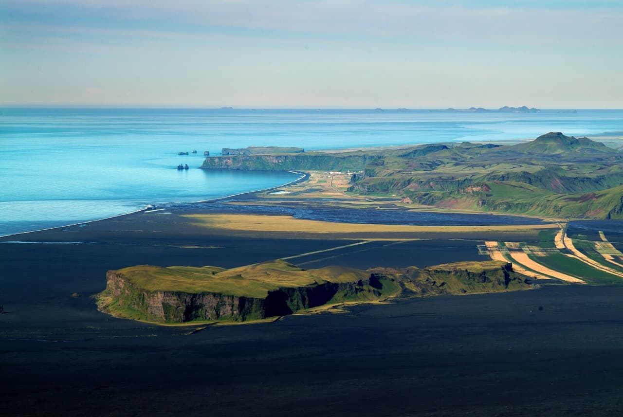 Hjörleifshöfði headland rising above black sands on the South Coast near Vík