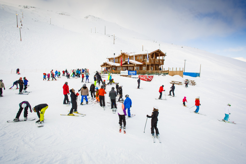 Skiers gathered near the base lodge on snowy Hlíðarfjall above Akureyri.