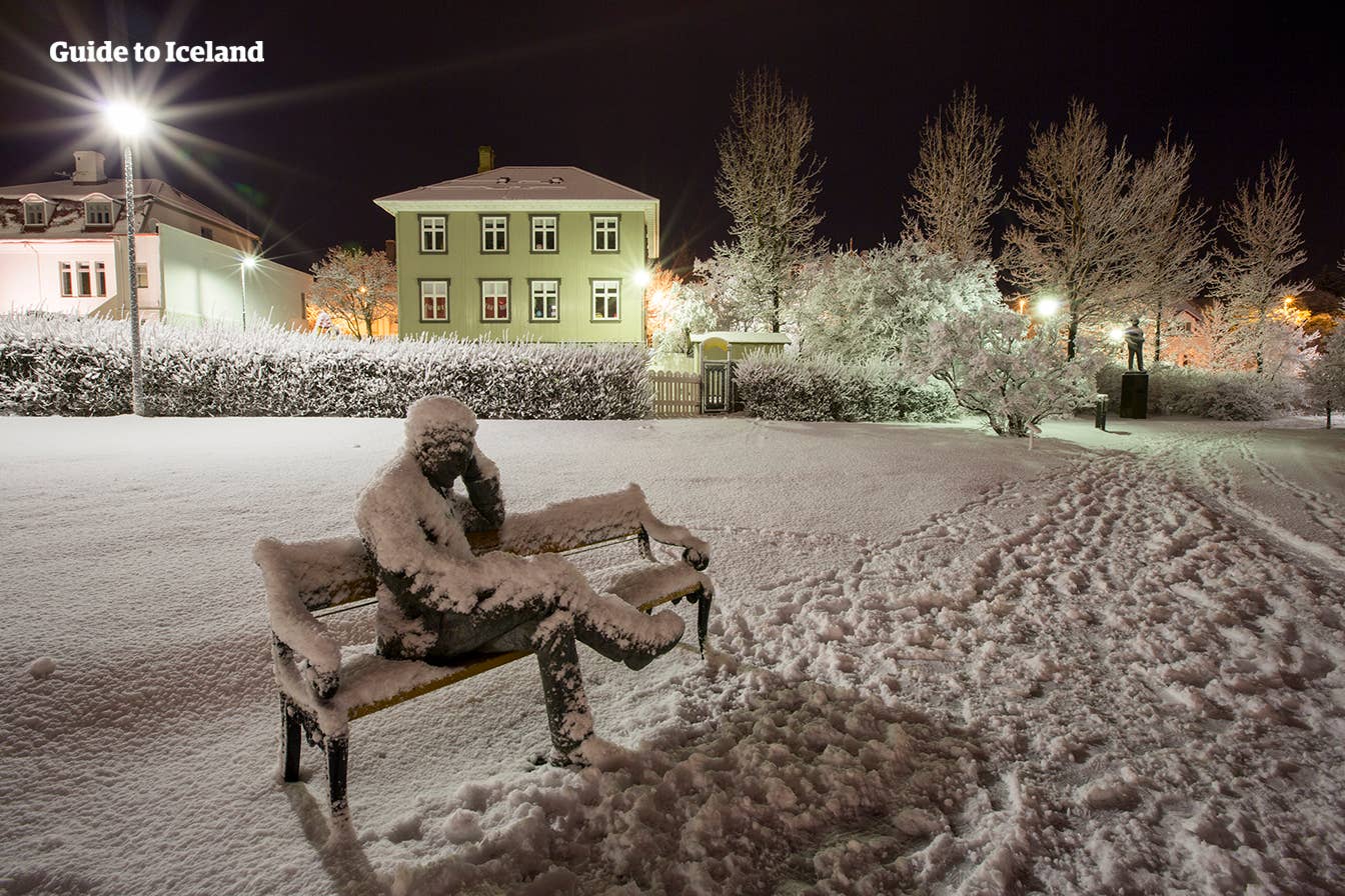 Snow-covered Tómas Guðmundsson statue in Hljómskálagarðurinn park in Reykjavík.
