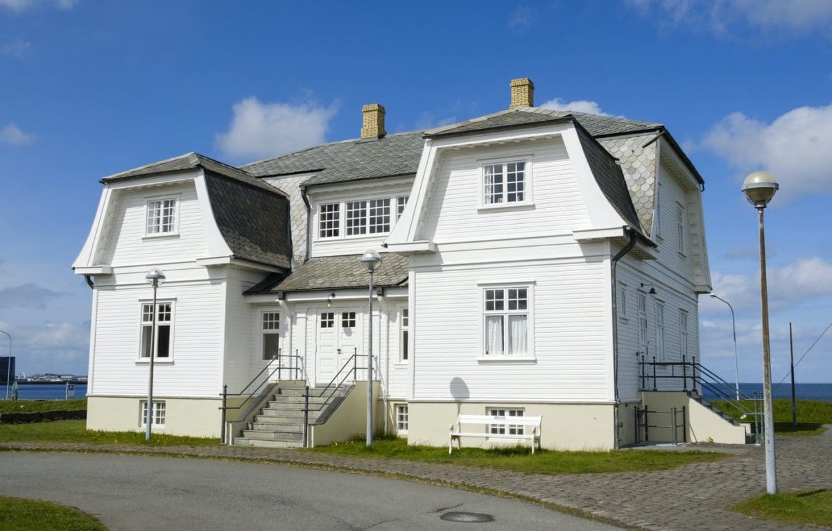 Front approach to the white timber Höfði house on a clear Reykjavík day