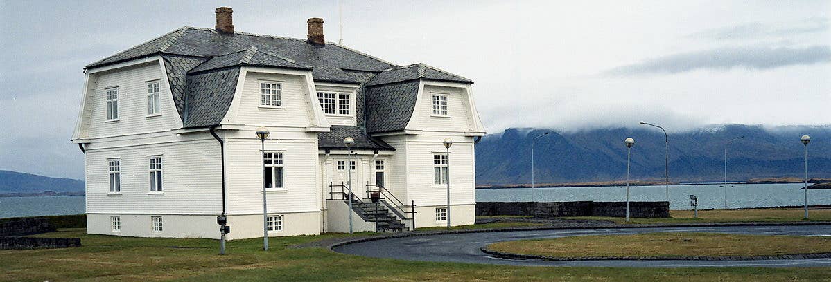 Wide waterfront view of Höfði house with mountains across the bay