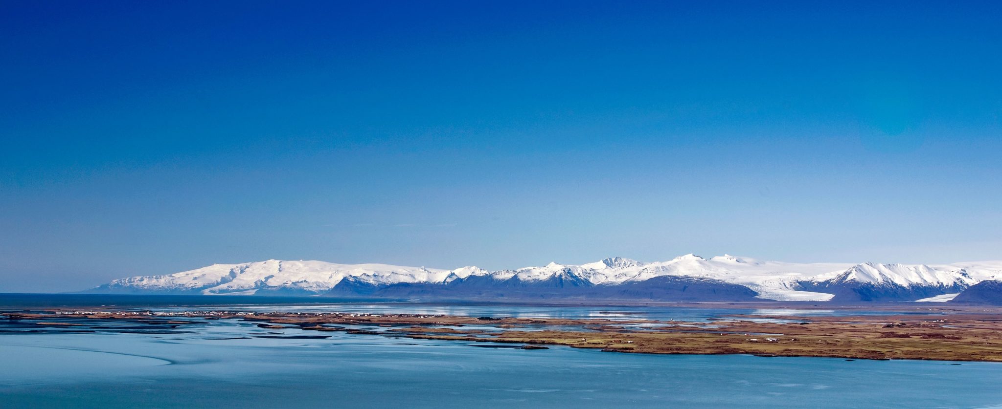 Wide view from Almannaskarð across Hornafjörður toward snowy Vatnajökull mountains.