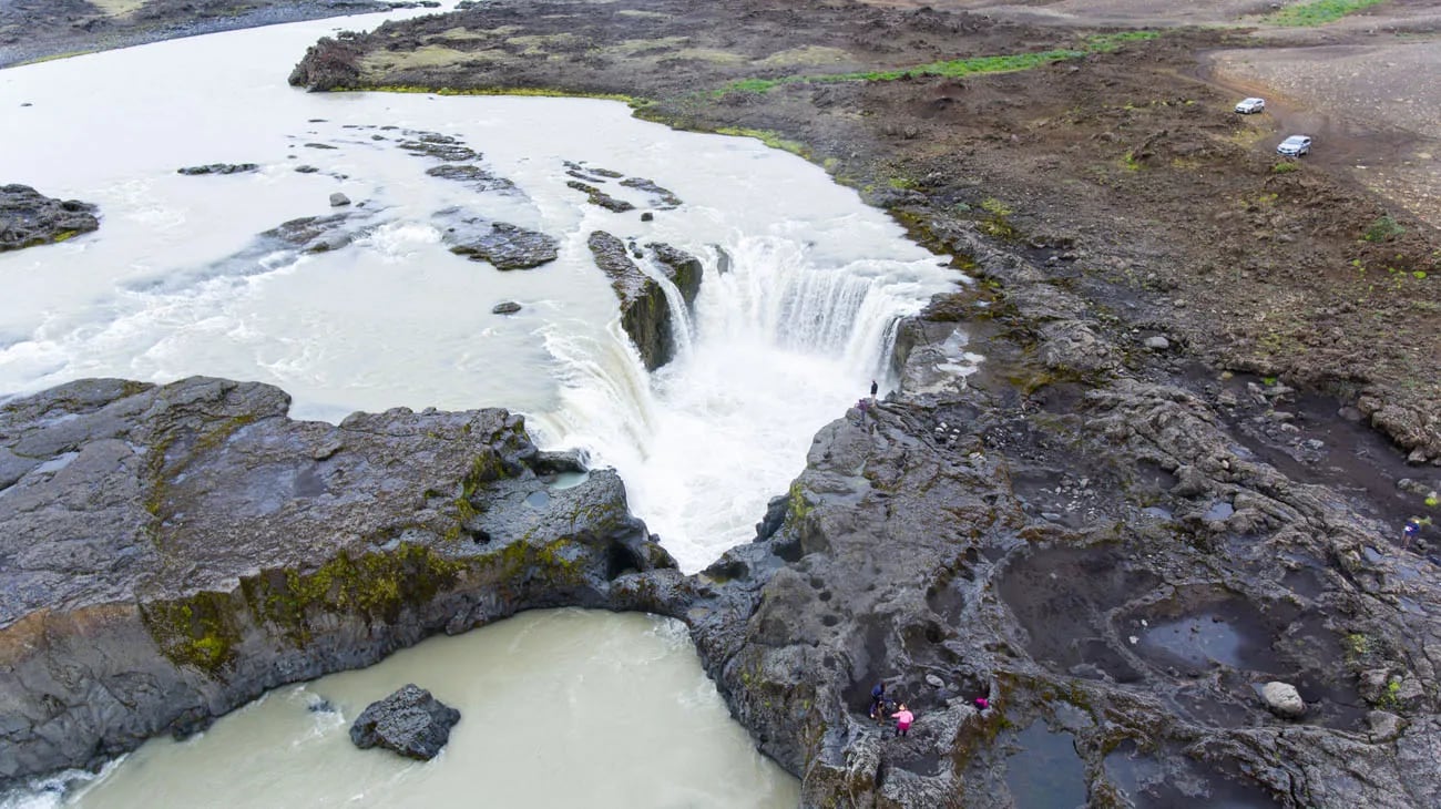Aerial view of Hrafnabjargafoss with braided white water and dark rock around the river.