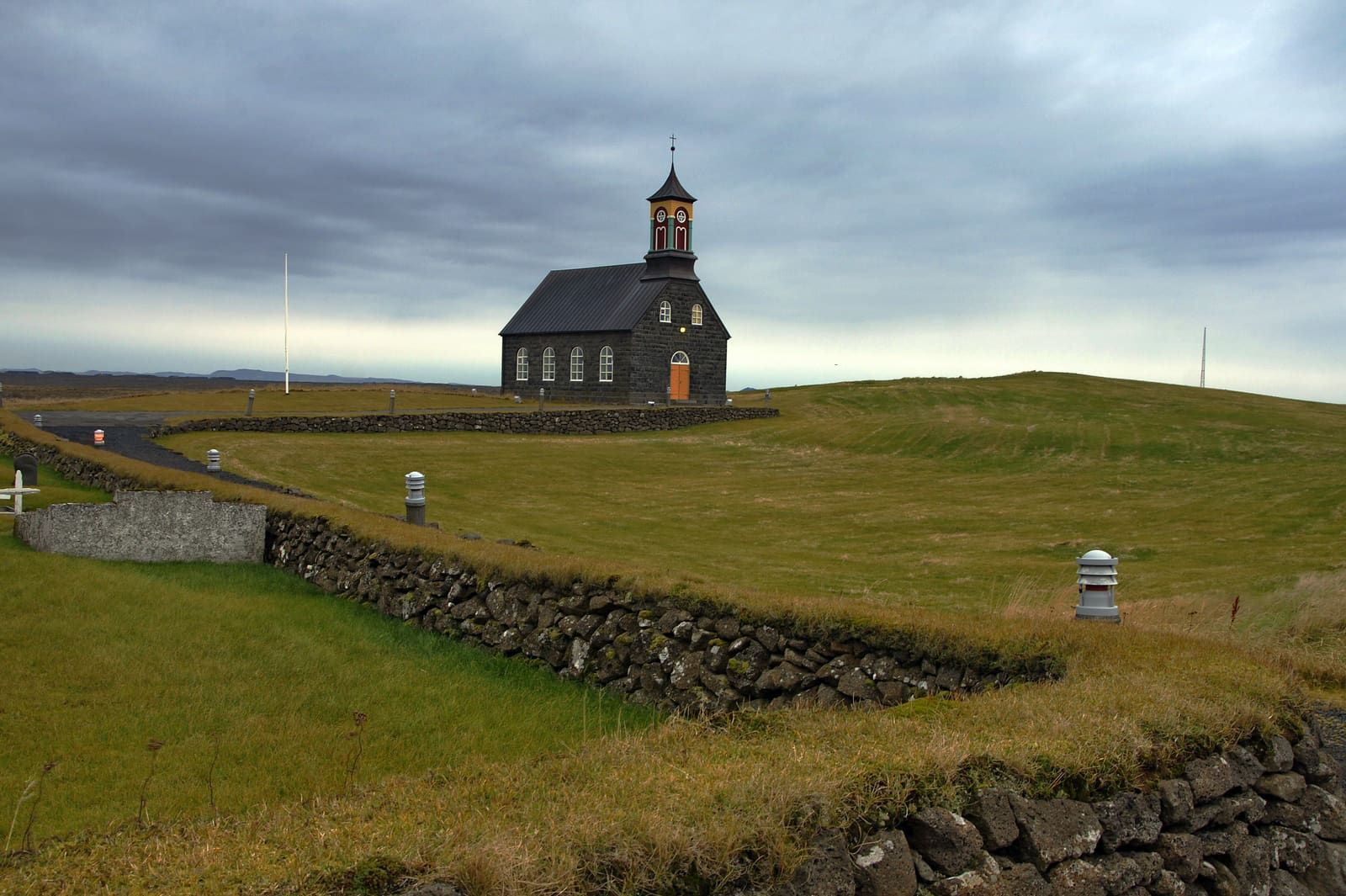 Hvalsneskirkja stone church and churchyard wall in the open Reykjanes landscape.