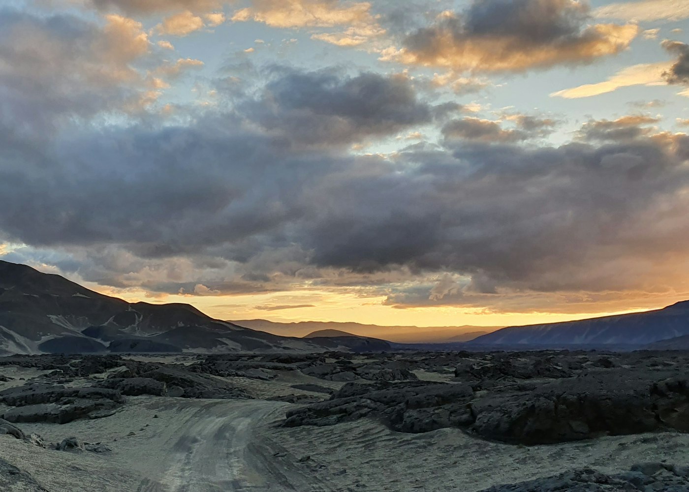 Rough track through dark Krepputunga lava terrain under clouds near the Hvannalindir highland approach.