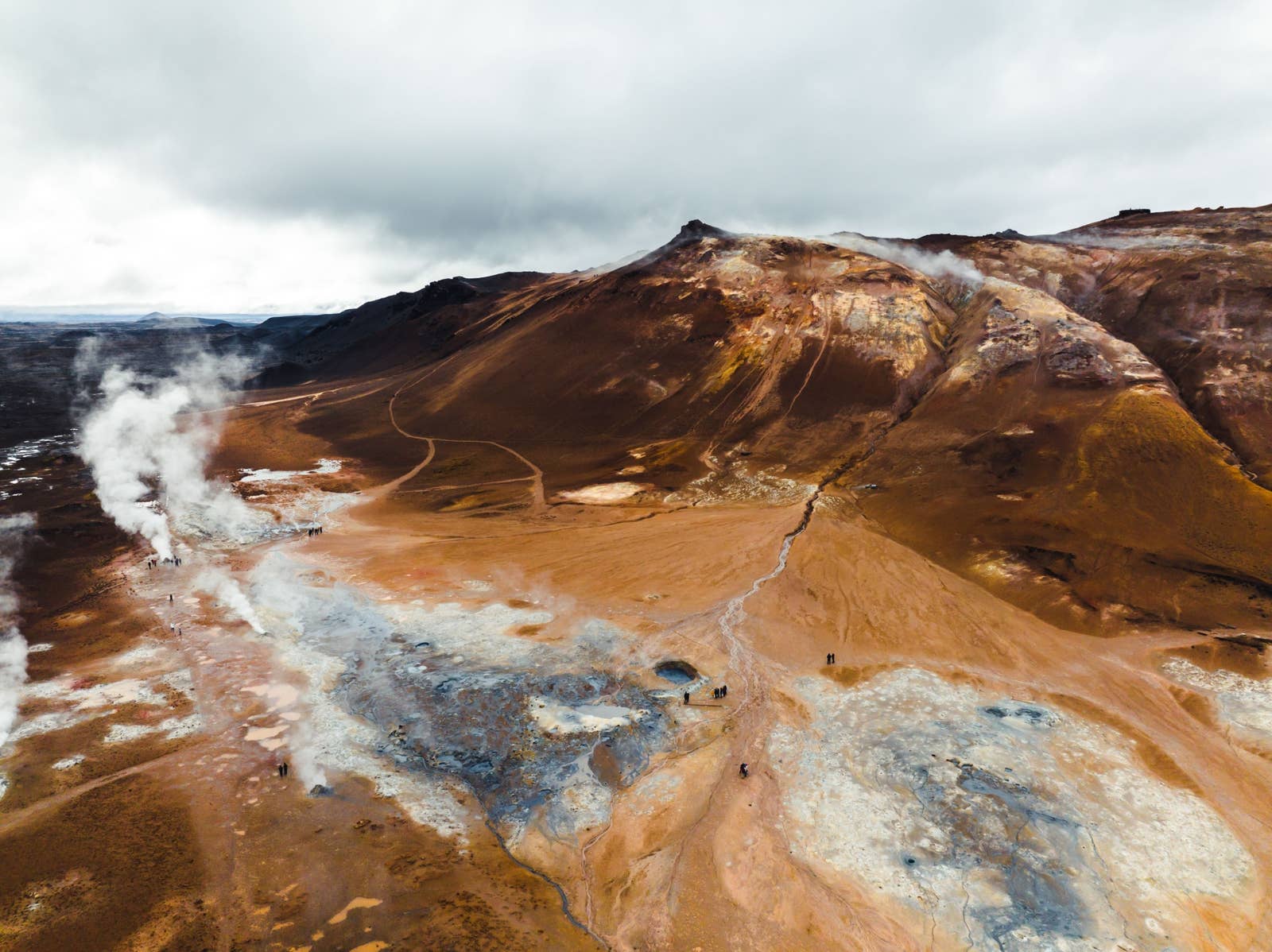 Aerial view of Hverir geothermal field, steam plumes, and the brown slopes of Námafjall.