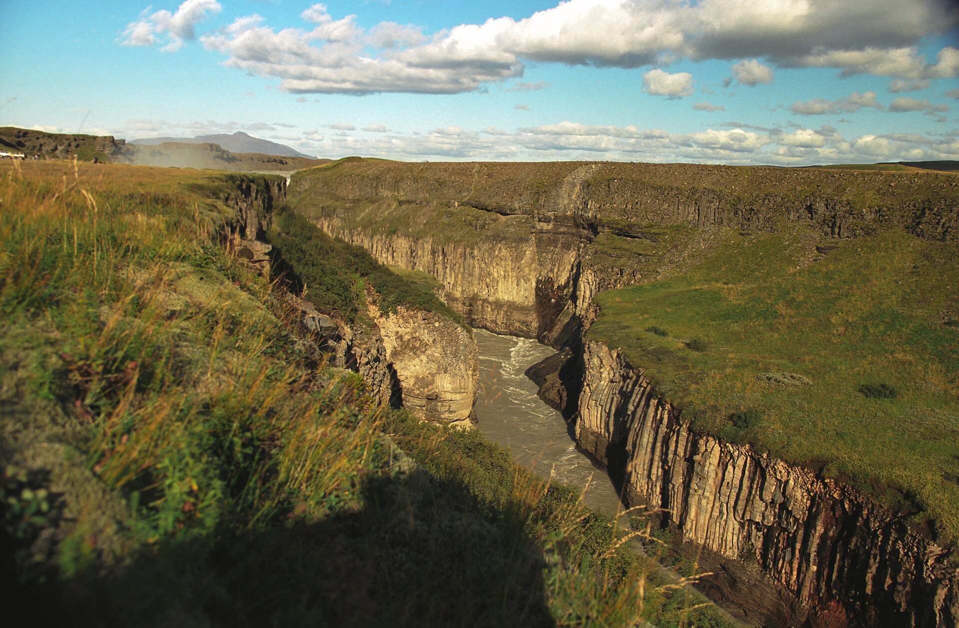 Hvítá River running through the Brúarhlöð gorge with steep rock walls and open South Iceland hills.