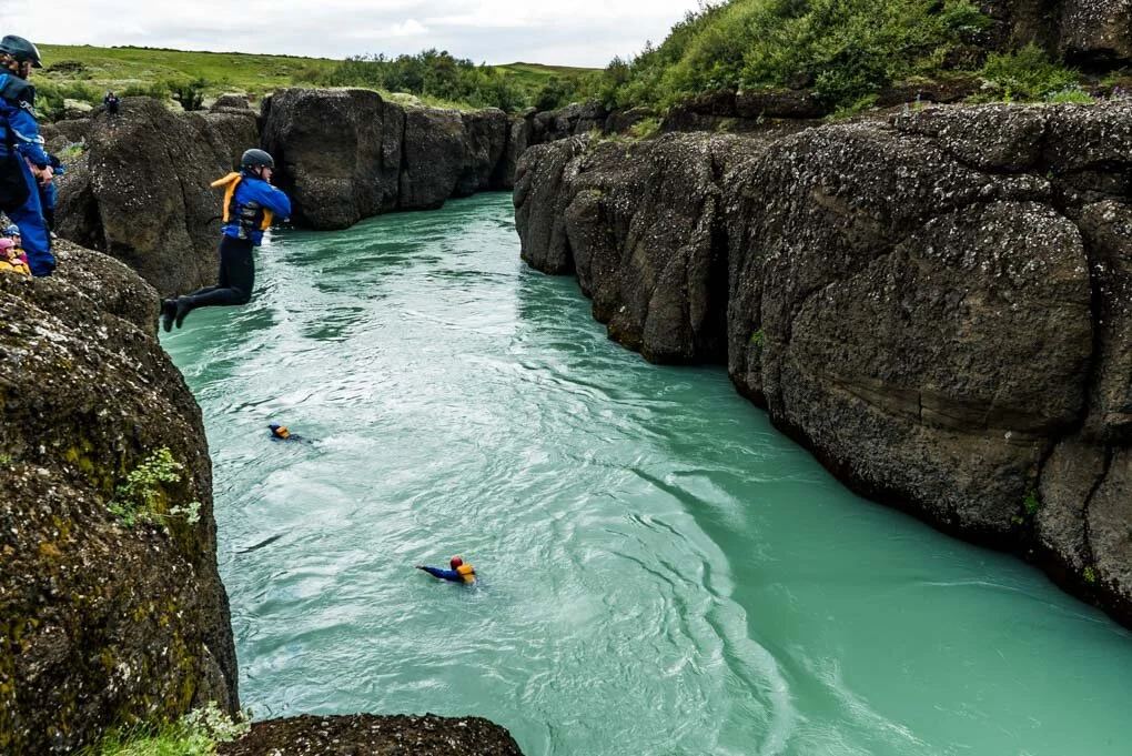 Guided river activity in the Brúarhlöð section of Hvítá River with dark canyon walls.
