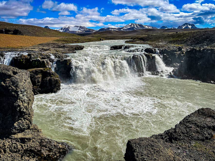 Pale Hvítárvatn water below Langjökull with bare highland ground in the foreground.