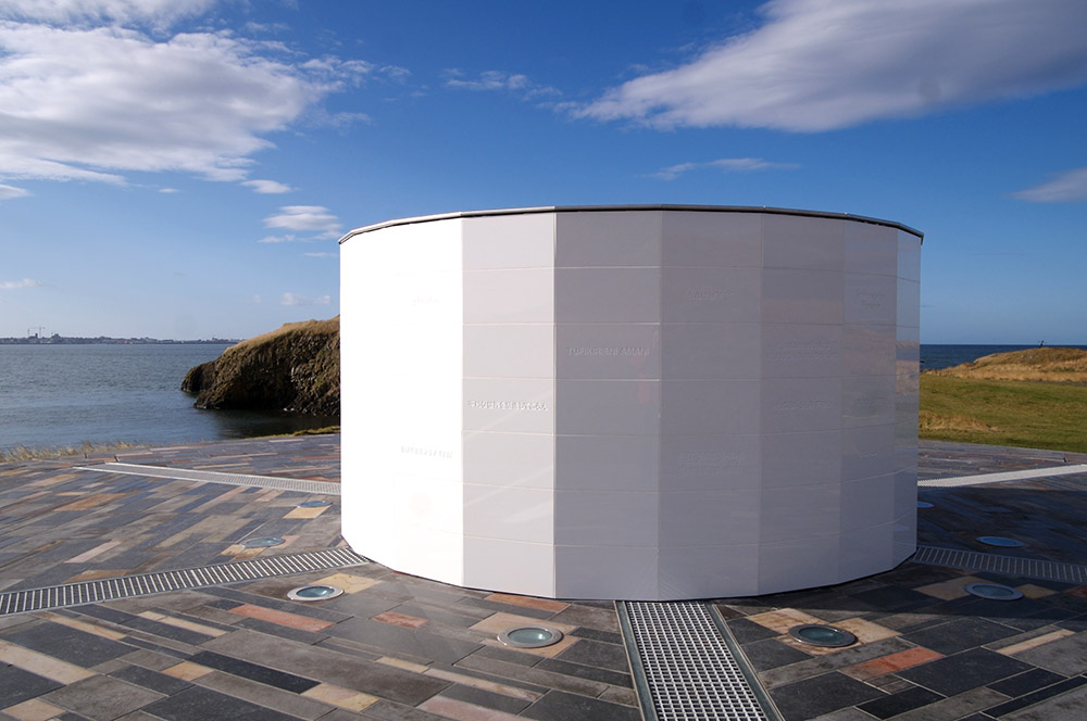 Daylight view of the white Imagine Peace Tower wishing well on Viðey