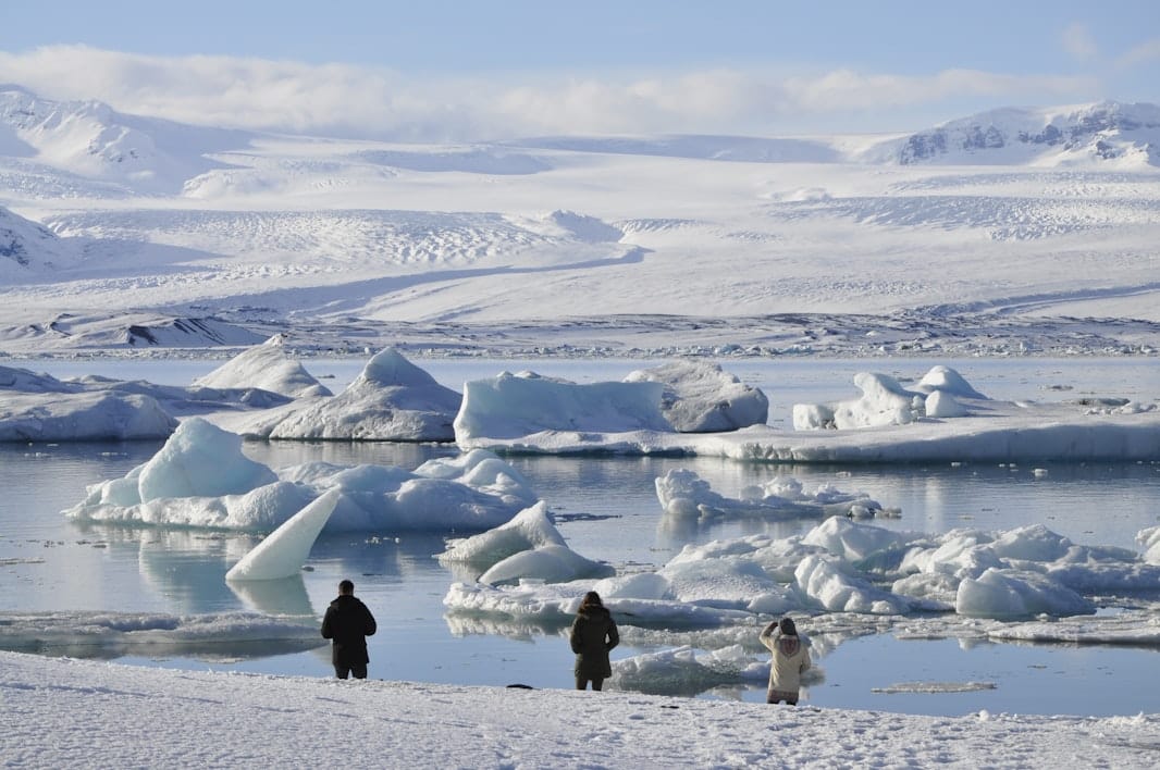 Visitors looking across winter icebergs at Jökulsárlón Glacier Lagoon.