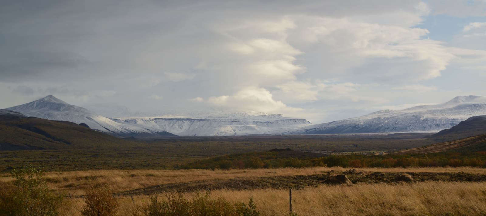 Snow-dusted mountains and open Kaldidalur valley terrain under changing highland weather.