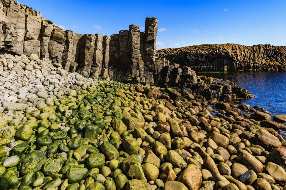 Basalt walls and rounded stones inside the cove at Kálfshamarsvík.
