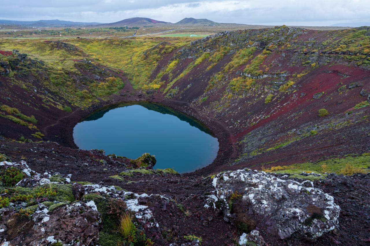 Kerið Crater lake and red volcanic rim in autumn colors on the Golden Circle.